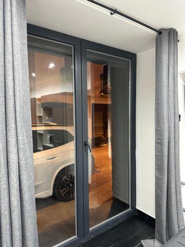 a sliding glass door with a car behind it at Studio aiguebelle in Randens