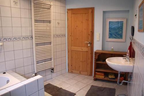 een badkamer met een wastafel, een toilet en een deur bij Freizeithof Hildesheimer Börde in Holle
