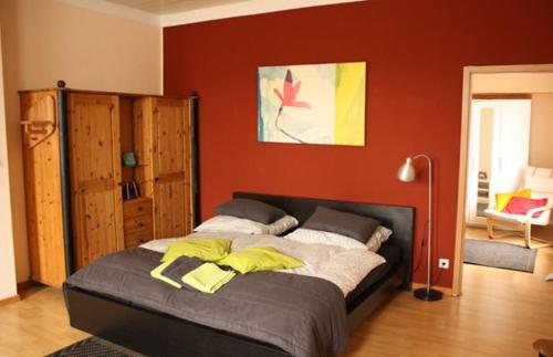 a bedroom with a large bed with a red wall at Freizeithof Hildesheimer Börde in Holle