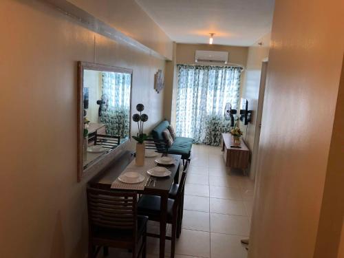 a dining room with a table and chairs and a living room at Majestic One Bedroom Condo Unit in Iloilo City
