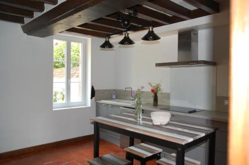 - une cuisine avec une table et un évier dans l'établissement Gîte du gre-nael, à Bonnée