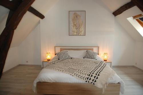 une chambre avec un lit avec deux lampes sur deux tables dans l'établissement Gîte du gre-nael, à Bonnée