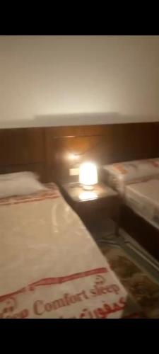 a bed room with a row of beds and a light at Oyster bay Suite 01 in Abu Dabab
