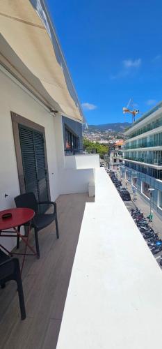 a balcony with a table and chairs on a building at Canavial Terrace@Heart of Funchal in Funchal