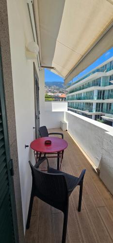 a red table and chairs on the balcony of a building at Canavial Terrace@Heart of Funchal in Funchal