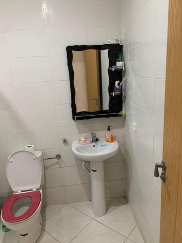 a bathroom with a toilet and a sink with a mirror at Sérénité en bord de mer à Tamaris piscine, plage et bonheur in Dar Mohammed Ould Haj Jilali