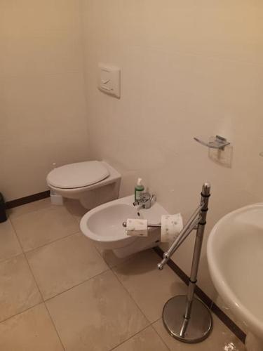 a white bathroom with a toilet and a sink at appartamento piano terra in Eraclea Mare