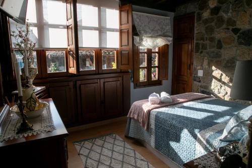 een slaapkamer met een bed in een kamer met ramen bij Casa Rural Salices in Pola de Laviana