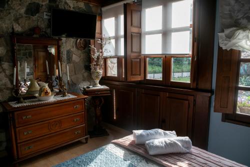 een slaapkamer met een dressoir en een bed met 2 handdoeken bij Casa Rural Salices in Pola de Laviana