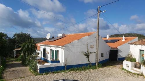 een klein wit huis met een oranje dak bij Casa Delfim - Casa Verde in Alte