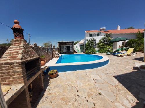 een zwembad in een tuin met een huis bij Casa Delfim - Casa Verde in Alte