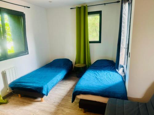 Zimmer mit 2 Betten und einem Fenster mit grünen Vorhängen in der Unterkunft Joli duplex climatisé à 30min Paris in Montmorency