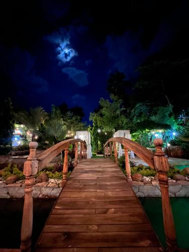 a wooden bridge over a pond at night at Finca las Isabeles in Xochitepec