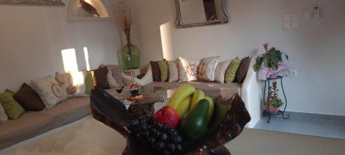 a living room with a couch with a bowl of fruit at Siroccos Apartment in Vlychádia