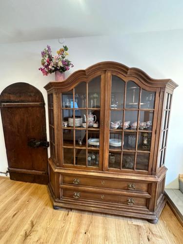 a wooden cabinet with a vase on top of it at Nannerls Penthouse in Sankt Gilgen