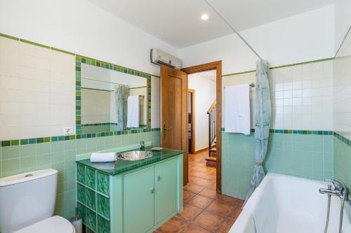 a bathroom with a toilet and a sink and a tub at La Casa del Abuelo in Cúllar-Vega