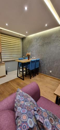 a living room with a table and a purple couch at Apartman Giron in Zlatibor