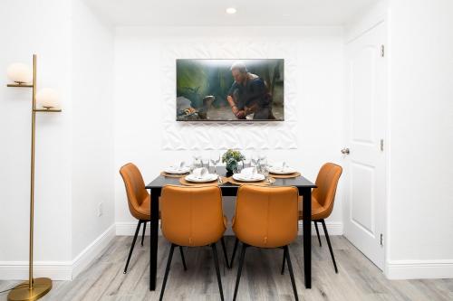 a dining room with a black table and orange chairs at Beautiful Zen Nest 1mile New EPIC Universe in Orlando