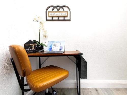 a desk with a orange chair and a table with at Beautiful Zen Nest 1mile New EPIC Universe in Orlando