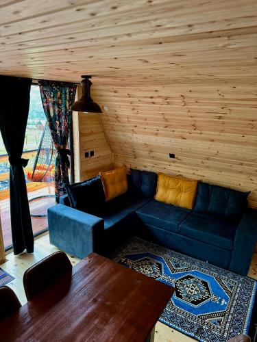 a living room with a blue couch and a table at Kazbegi Inn Cottages in Stepantsminda