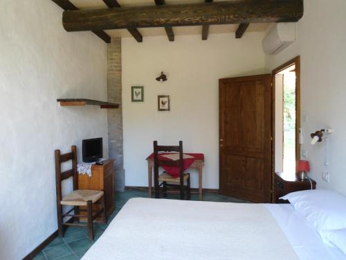 a bedroom with a bed and a desk and a tv at La Lepre Bianca in Cento