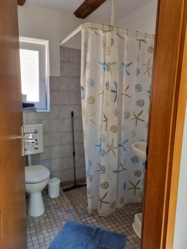 a bathroom with a shower curtain with fish on it at Ferienhof Bisdorf "Lunauhaus" Reihenhaus in Bisdorf