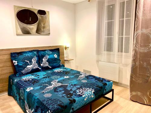 une chambre avec un lit avec une couette bleue dans l'établissement Louis Pacello Appartement, à Amboise