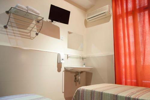 a small room with a sink and a bed at Be Ramblas Guest House in Barcelona
