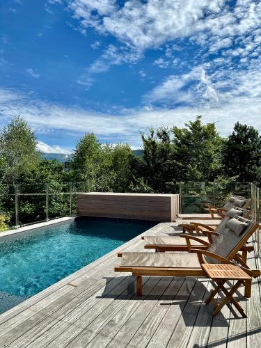 - une piscine avec des chaises et une table à côté d'une terrasse dans l'établissement Le Chalet Hôtel Cordon Adults Only, à Cordon