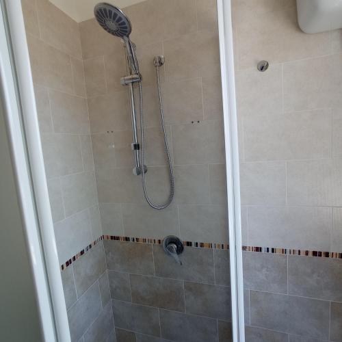 a shower with a shower head in a bathroom at Alloggio panoramico sul mare di Vindicio in Formia