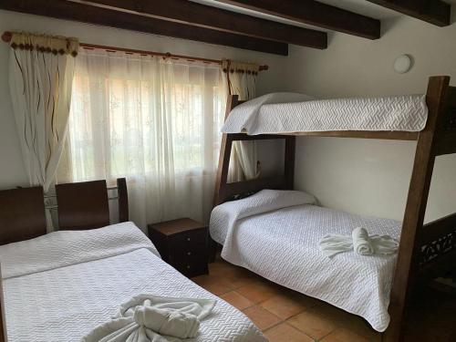 Un dormitorio con dos literas y una ventana. en Apartamento Madeiro, en Villa de Leyva
