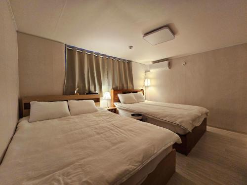 a hotel room with two beds and a window at An-sik The Seoul in Seoul