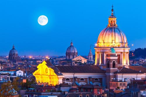 a view of a city at night with a full moon at Casa Italia Hospitality in Lunghezza
