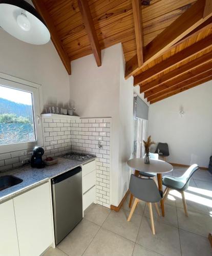 Una cocina con una mesa y una mesita con sillas. en El departamento esperado en el Sur - Edificio Loretta I, en San Martín de los Andes