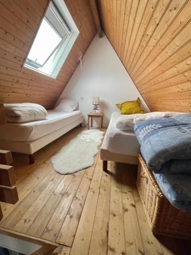- une chambre mansardée avec 2 lits et une fenêtre dans l'établissement Refuge des Sables Marins, à Barneville-Carteret
