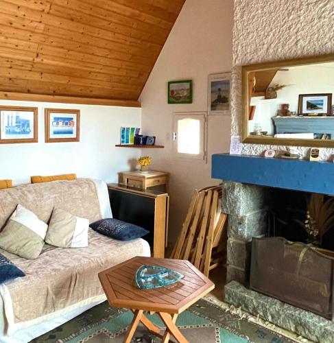 un salon avec un canapé et une cheminée dans l'établissement Refuge des Sables Marins, à Barneville-Carteret
