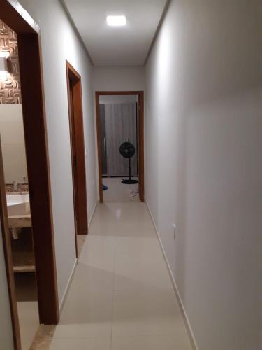 un corridoio che conduce a un bagno con lavandino di Recanto Nery Cabrália Casa temporada a Santa Cruz Cabrália