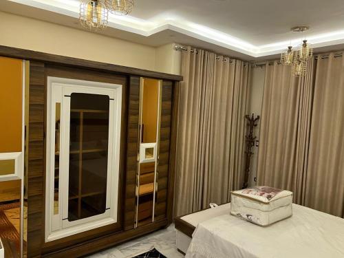 a bedroom with a mirror and a bed with a dresser at شقة فندقية vip برج رئيسي شارع الغشام مع موقف المنصورة in Manshīyat as Sādāt