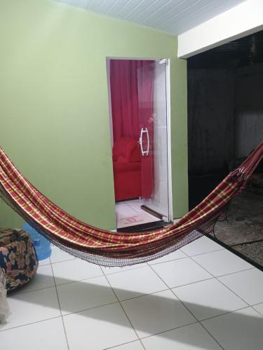a hammock in a room with a red couch at Casa Temporada em Barreirinhas in Barreirinhas