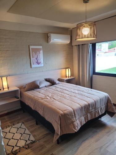 a bedroom with a large bed and a large window at Casa en calle Mondello, Piriápolis in Piriápolis