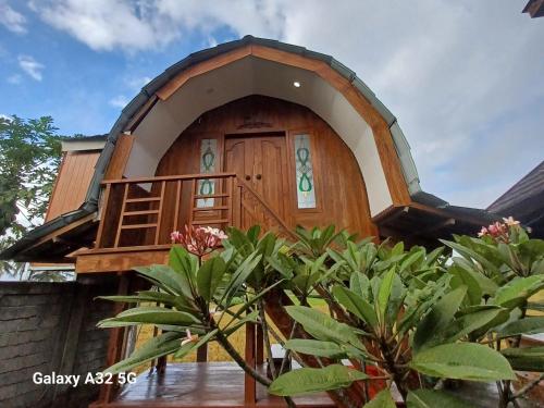 a small wooden house with a round door at Bujak Permai Villa Matahari Lombok NTB in Praya