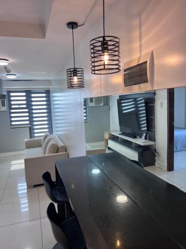 una sala de estar con una gran mesa negra y sillas. en 1 bedrm condo, Tower 2, Hor 101, en Cebú