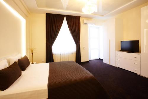 a bedroom with a large bed and a television at Central Park Apartments in Chişinău