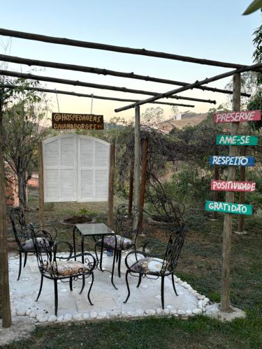 a group of chairs and a table under a canopy at Hospedagem Recanto das Orquideas in Quatis