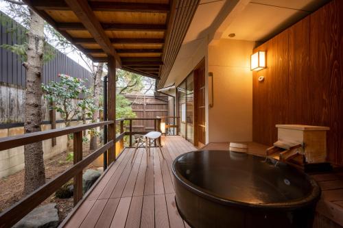 a bath tub on the deck of a house at Hohoemino Kuyufu Tsuruya in Tendo