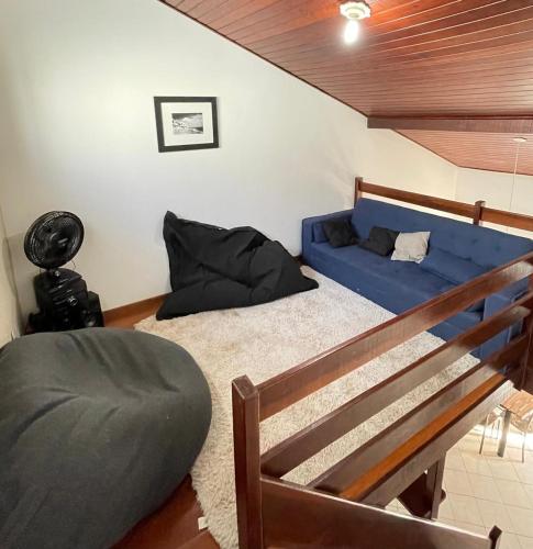 a bedroom with a bed and a blue couch at Recanto no Caribe in Arraial do Cabo