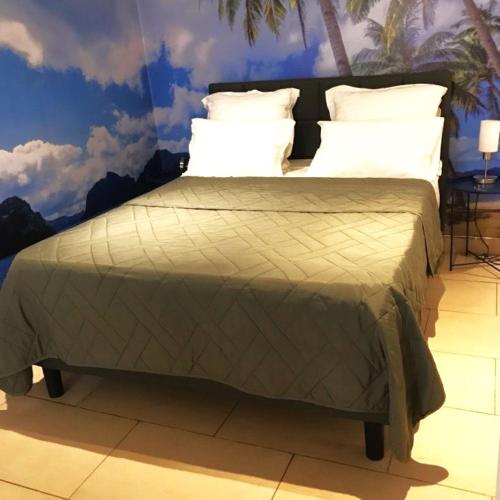 - un lit avec une couette verte et des oreillers blancs dans l'établissement Summer Beach Studio, 4 persons, mobile AC, Old Town, à Nice