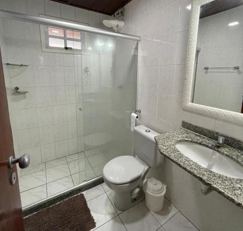 a bathroom with a shower and a toilet and a sink at Recanto no Caribe in Arraial do Cabo