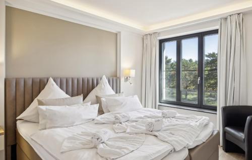 a white bedroom with a large bed with white pillows at Cloud in Binz