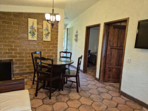 a dining room with a table and chairs and a brick wall at La Cabaña Zacatlán in Zacatlán